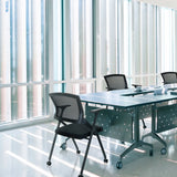 Silla plegable PRIORITY II en negro con respaldo de malla en una mesa de conferencias de hjh OFFICE