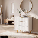 Cómoda Hjelle K blanca con frentes acanalados y tiradores y patas en color dorado de hjh LIVING (imagen generada por IA)