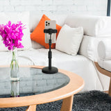 Soporte para teléfono móvil y tableta FLEXMOBI II negro con un smartphone sobre una mesa de cristal frente a un sofá blanco de hjh OFFICE