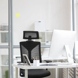 Silla de oficina profesional KODIAK negra con respaldo de malla y reposacabezas en un escritorio blanco de hjh OFFICE