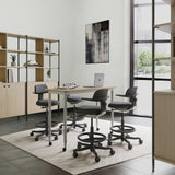 Cuatro sillas de trabajo TOP WORK 40 en color gris oscuro con reposabrazos y reposapiés en un escritorio blanco de hjh OFFICE