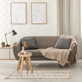 Taburete RUSTIKO W de madera marrón como mesa auxiliar delante de un sofá gris de hjh LIVING