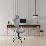 Silla de oficina profesional BRETON PRO W de color gris con reposacabezas y reposabrazos frente a un escritorio minimalista de hjh OFFICE
